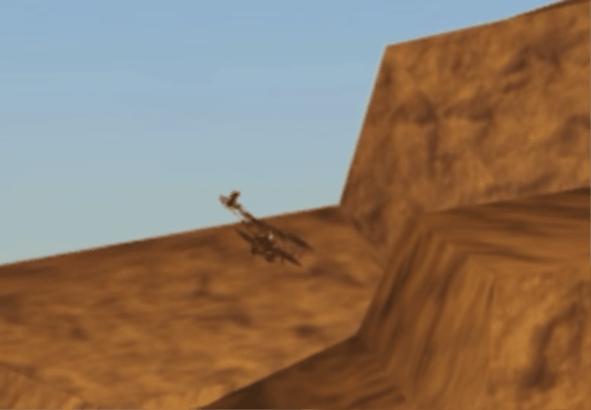 A biplane flying past a desert canyon wall